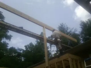 Carpenter setting a ridge beam over a new addition frame — Ice Dam Removal by Roofing Brothers in Pinetops