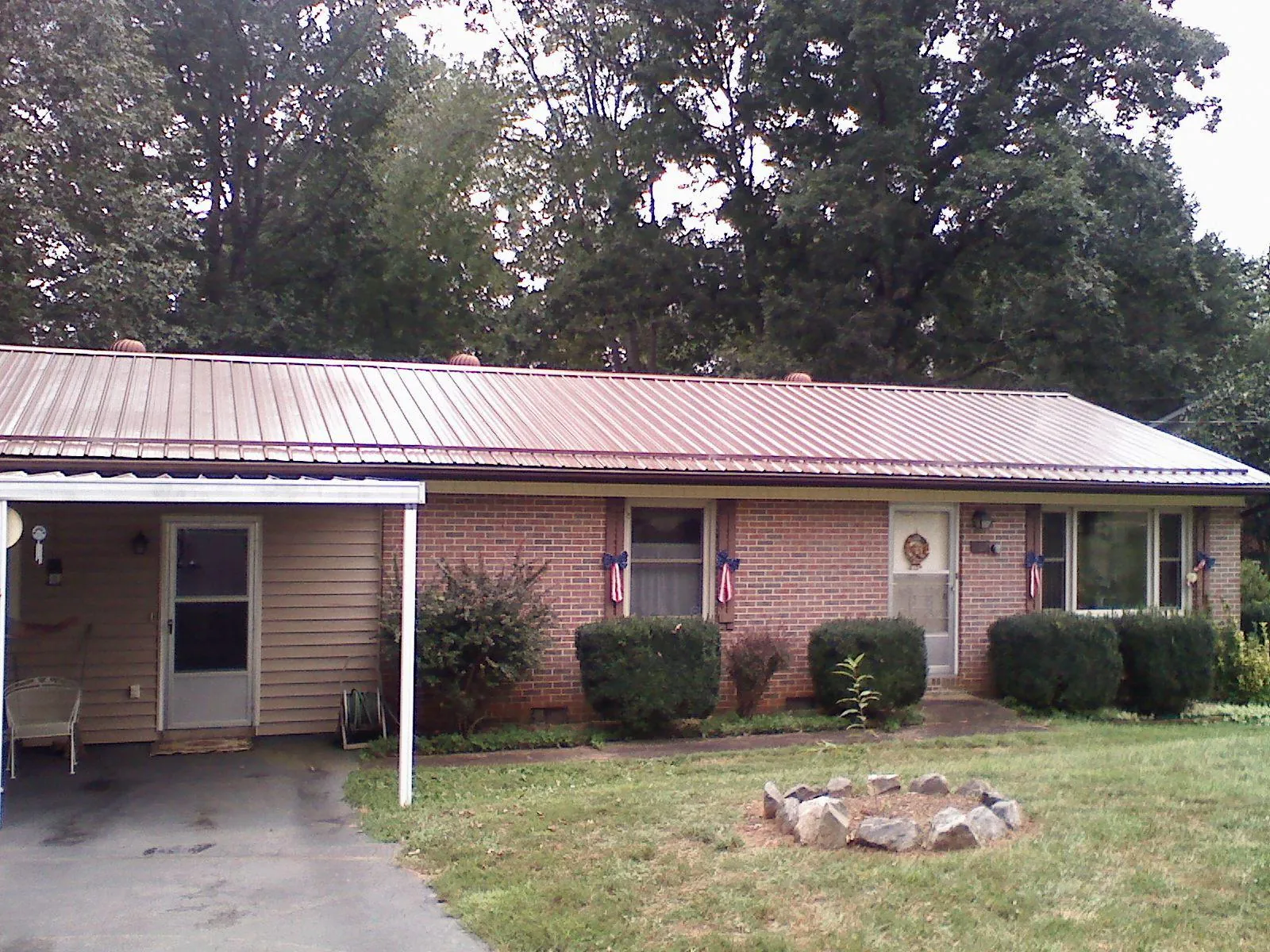 Bronze metal roof and carport on a brick ranch home — Roof Repair work by our crew in Pinetops